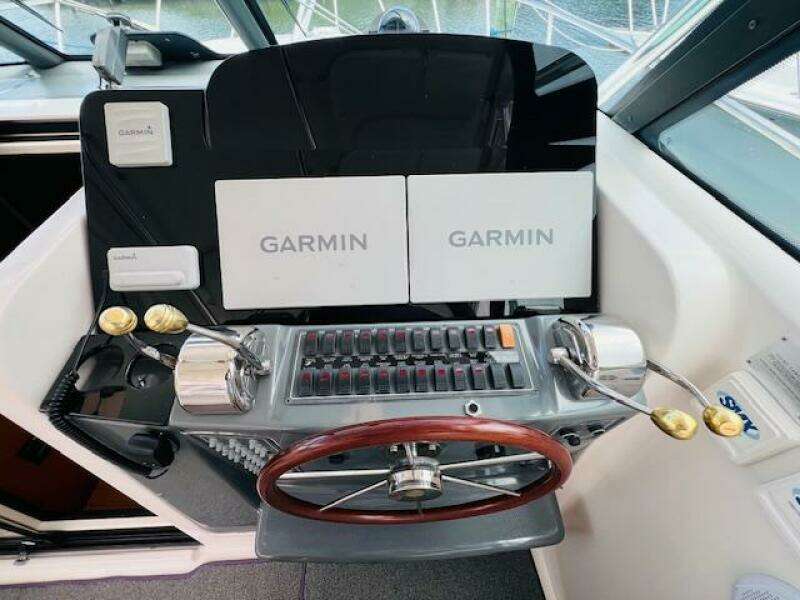Tiara Yachts 3800 Open 2003 helm with Garmin navigation displays and wooden steering wheel.