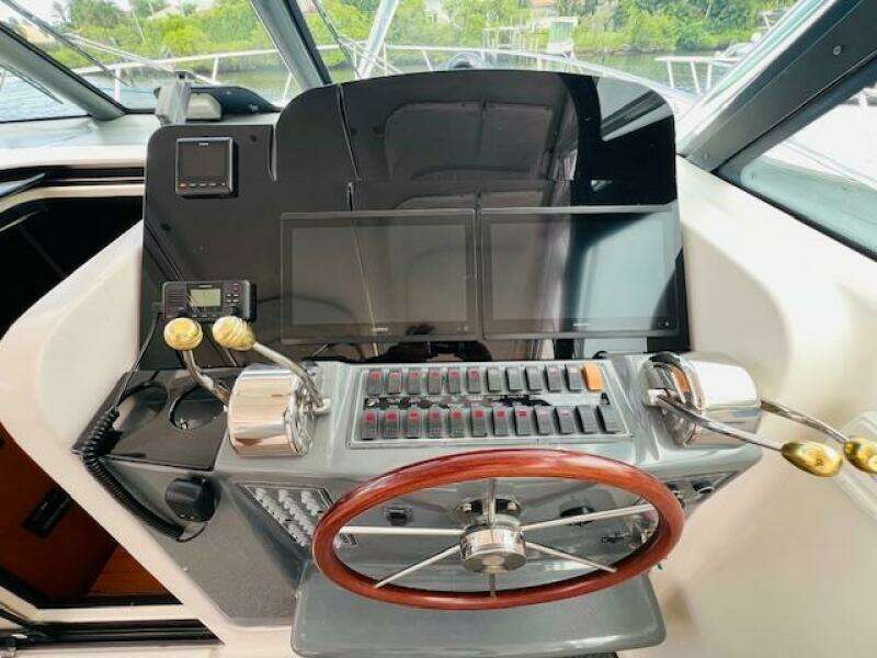 Tiara Yachts 3800 Open 2003 helm with wooden steering wheel and modern controls.