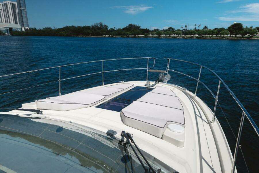 2015 Beneteau Monte Carlo 5 yacht deck with sun loungers on calm water.