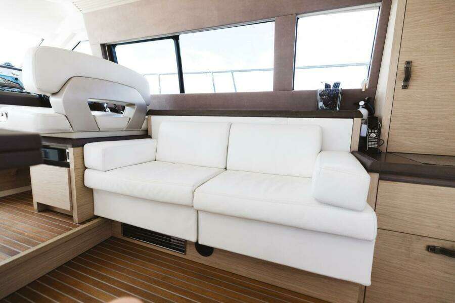 Luxurious interior of 2015 Beneteau Monte Carlo 5 yacht with white sofa and wooden flooring.