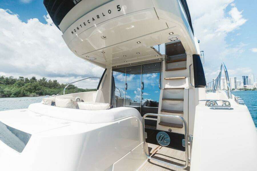 2015 Beneteau Monte Carlo 5 yacht, luxurious deck view with city skyline in background.