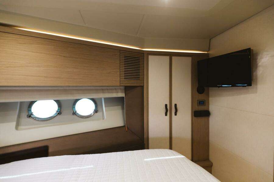 Luxurious cabin interior of 2015 Beneteau Monte Carlo 5 yacht with portholes and TV.