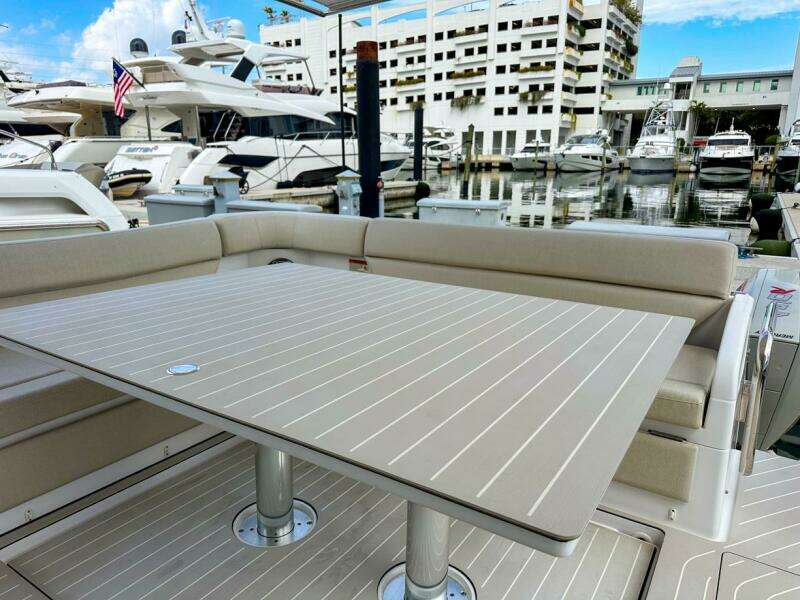 2023 Azimut Verve 47 yacht with elegant outdoor seating and table at marina.