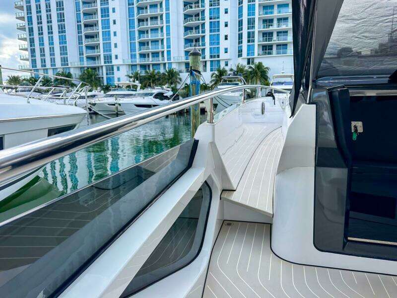 2023 Azimut Verve 47 yacht docked near modern waterfront buildings.