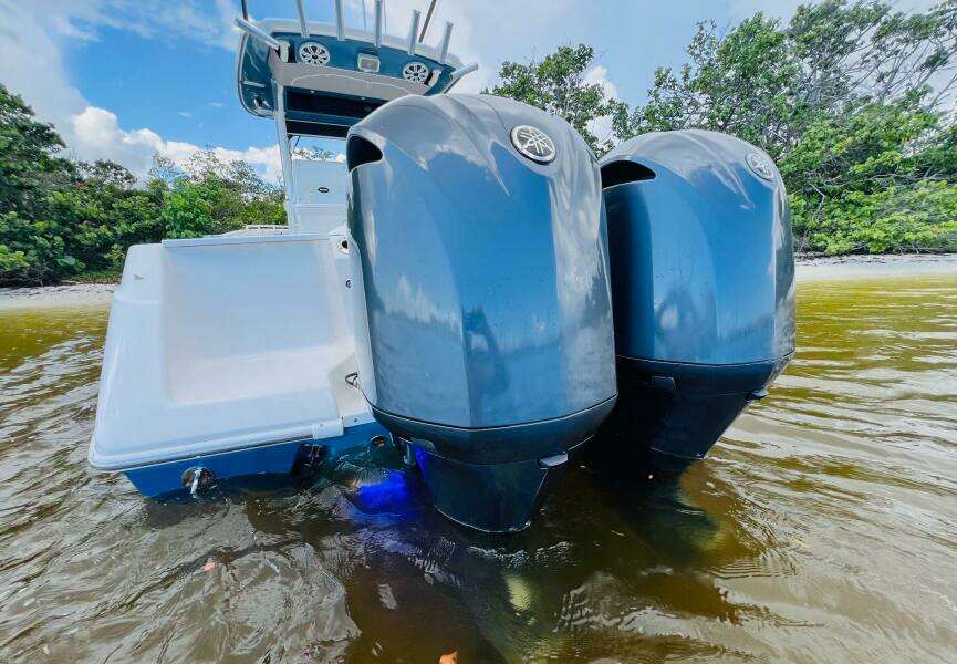 2012 Everglades 295 Center Console boat with dual outboard motors in shallow water.