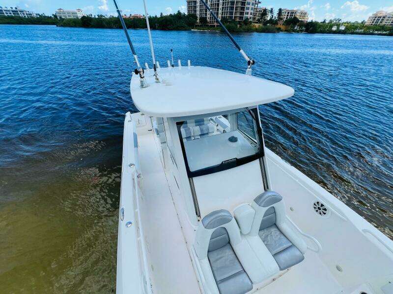 2012 Everglades 295 Center Console boat on calm water, featuring sleek design and fishing rods.