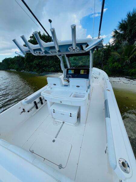 2012 Everglades 295 Center Console boat on a serene shoreline.