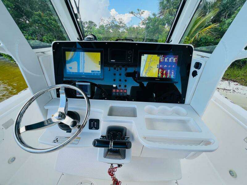 2012 Everglades 295 Center Console boat dashboard with navigation screens and steering wheel.