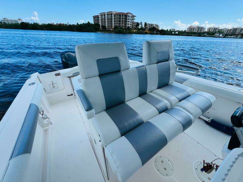 2012 Everglades 295 Center Console boat with striped seating, on a calm waterfront.