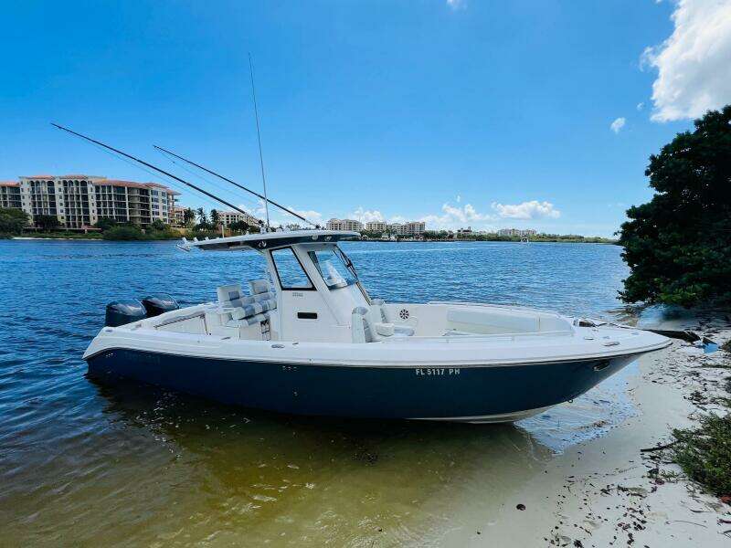 2012 Everglades 295 Center Console boat on sandy shore, clear blue sky.
