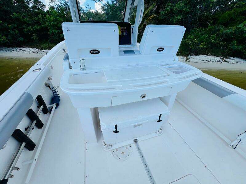 2012 Everglades 295 Center Console boat interior with seating and storage, near a sandy shore.