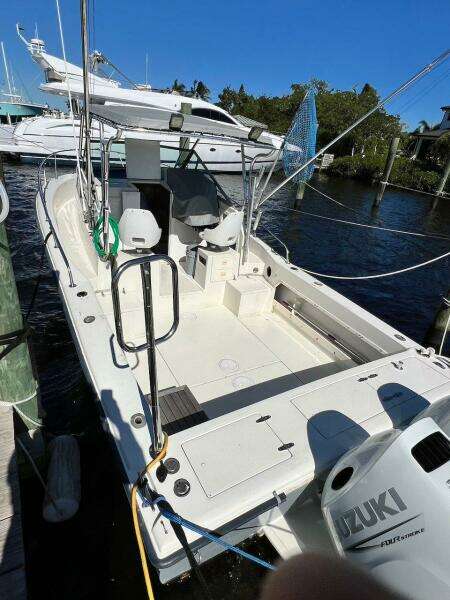 1988 Grady-White 25 SAILFISH boat docked with Suzuki outboard motor.