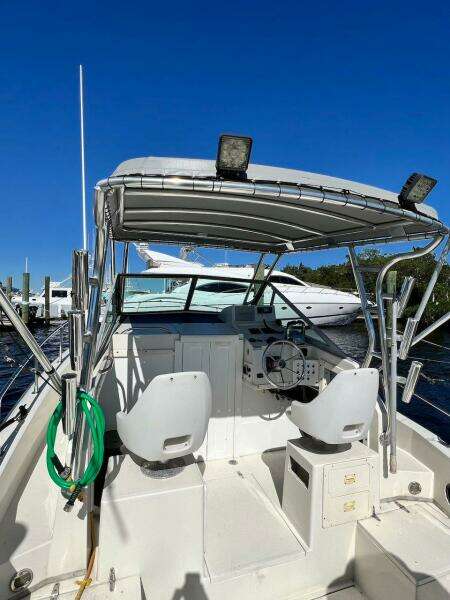 1988 Grady-White 25 SAILFISH boat with dual seats and canopy, docked under clear blue sky.