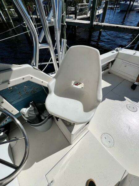 1988 Grady-White 25 Sailfish boat cockpit with white captain's chair and steering wheel.