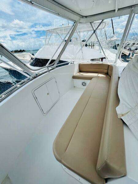 1988 Bertram 54' yacht interior with beige seating and marina view.