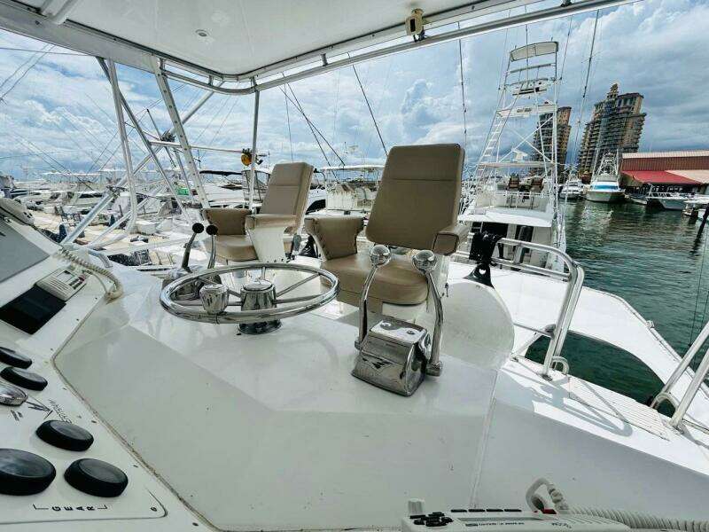 1988 Bertram 54' yacht helm with dual captain chairs at marina.
