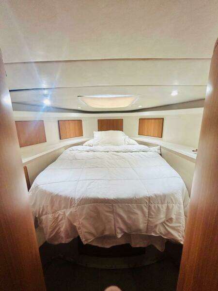 Luxurious bedroom interior of 1988 Bertram 54' yacht with cozy bedding.