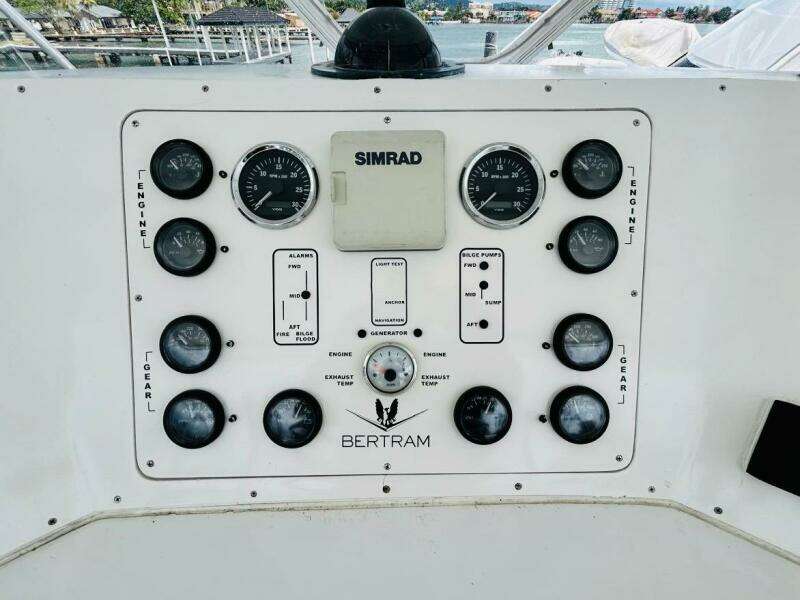 Control panel of a 1988 Bertram 54' yacht with gauges and Simrad equipment.
