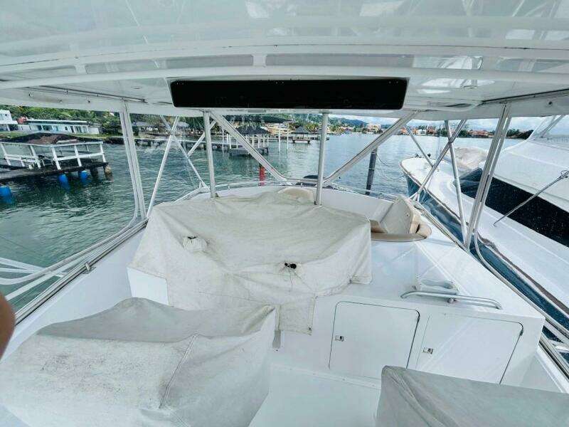 1988 Bertram 54' yacht deck with covered seating, docked at marina.