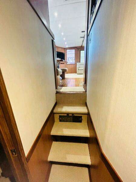 Interior view of 1988 Bertram 54' yacht, featuring carpeted stairs and wood-paneled walls.