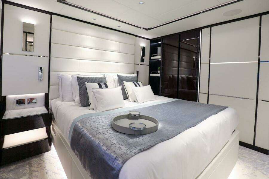 Luxurious bedroom interior on 2025 Majesty 120 yacht, featuring elegant bedding and modern design.