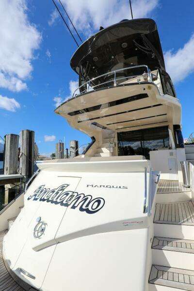 2016 Marquis 660 Sport Yacht docked under blue sky.
