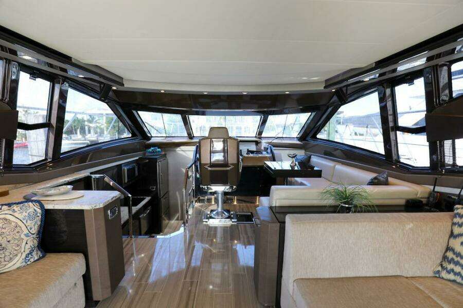 Luxurious interior of 2016 Marquis 660 Sport Yacht with modern seating and panoramic windows.