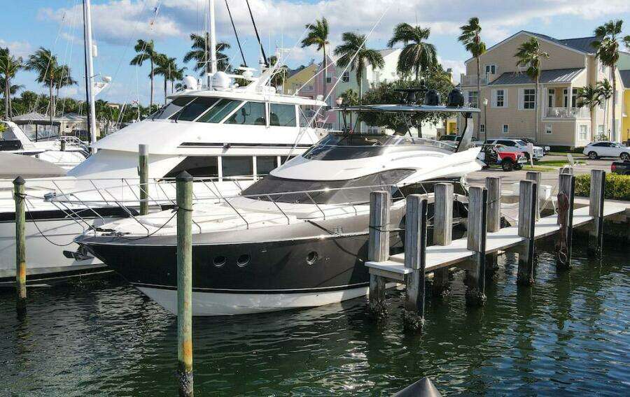 2016 Marquis 660 Sport Yacht docked at marina with palm trees.