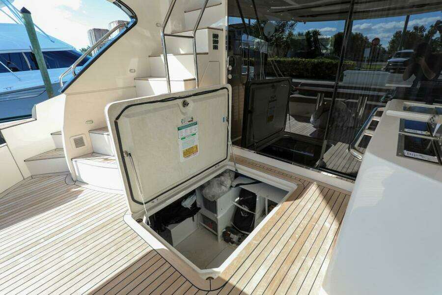 Open hatch on 2016 Marquis 660 Sport Yacht deck, revealing storage compartment.