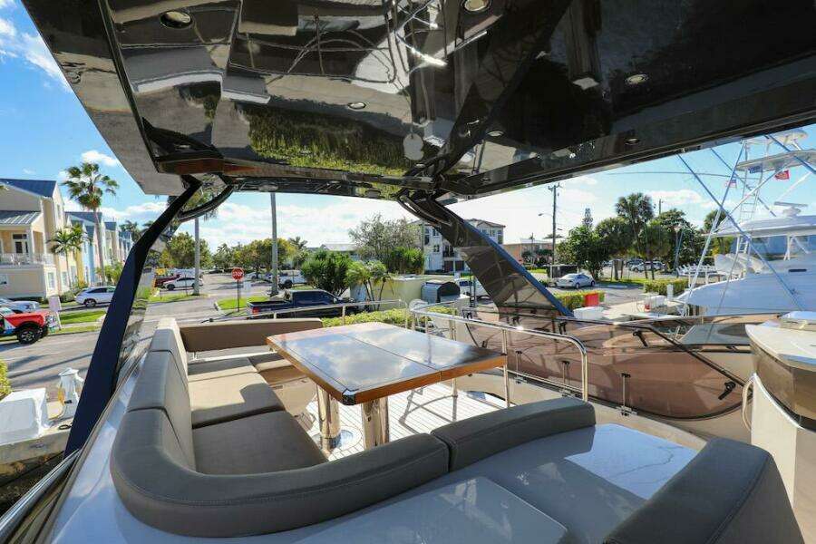 Luxurious 2016 Marquis 660 Sport Yacht with spacious outdoor seating and dining area.