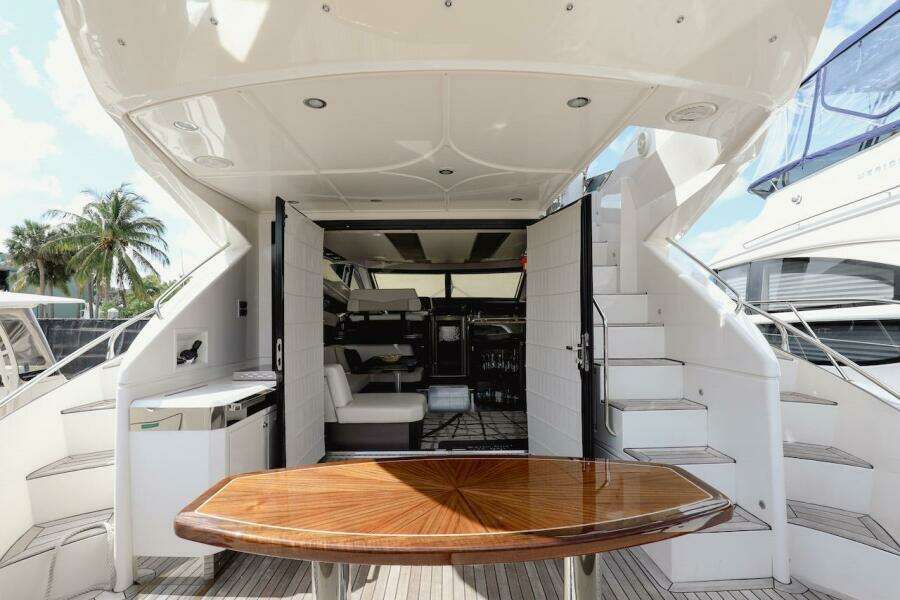 2017 Marquis 500 Sport Yacht interior with wooden table and white seating.