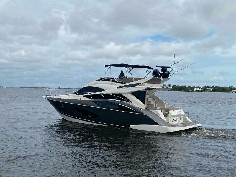 2017 Marquis 500 Sport Yacht cruising on a calm, cloudy day.