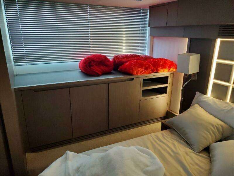 Modern bedroom interior of 2020 Galeon 500 Fly yacht with sleek cabinetry and window blinds.