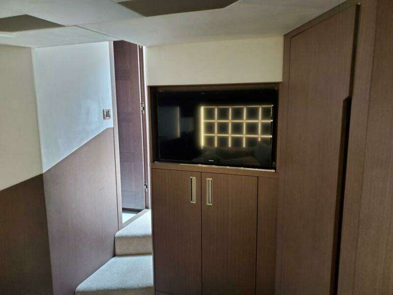 Interior of 2020 Galeon 500 Fly yacht with TV and wooden cabinetry.