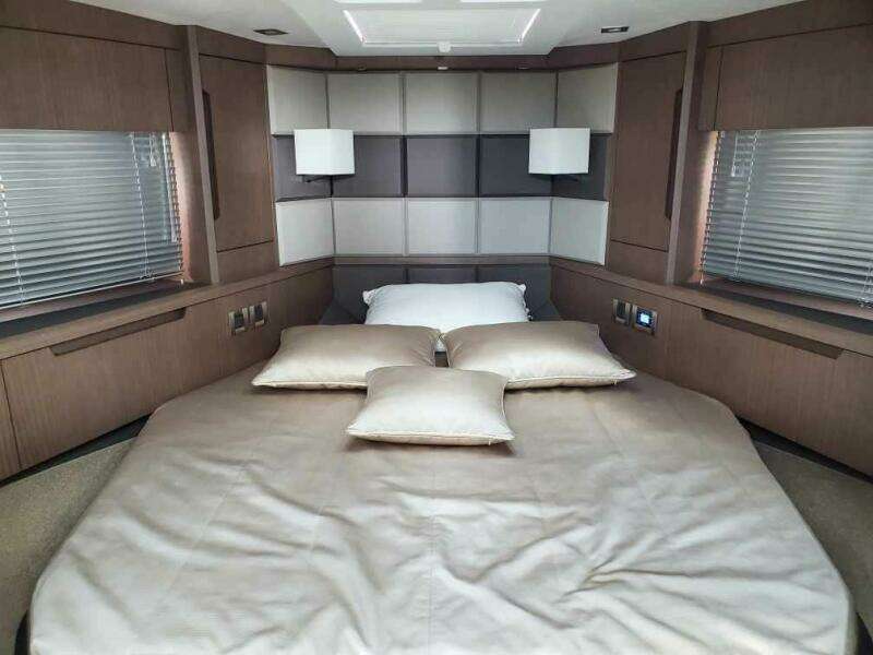 Luxurious bedroom in 2020 Galeon 500 Fly yacht with modern decor and ample natural light.
