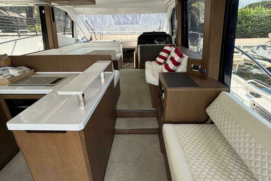 Luxurious interior of 2020 Galeon 500 Fly yacht with modern seating and kitchen area.