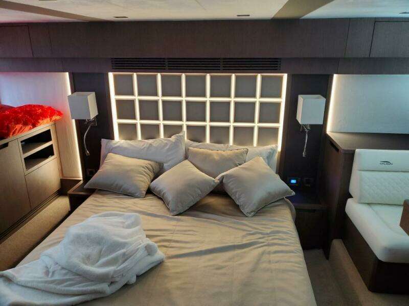 Luxurious bedroom in 2020 Galeon 500 Fly yacht with modern lighting and cozy bedding.