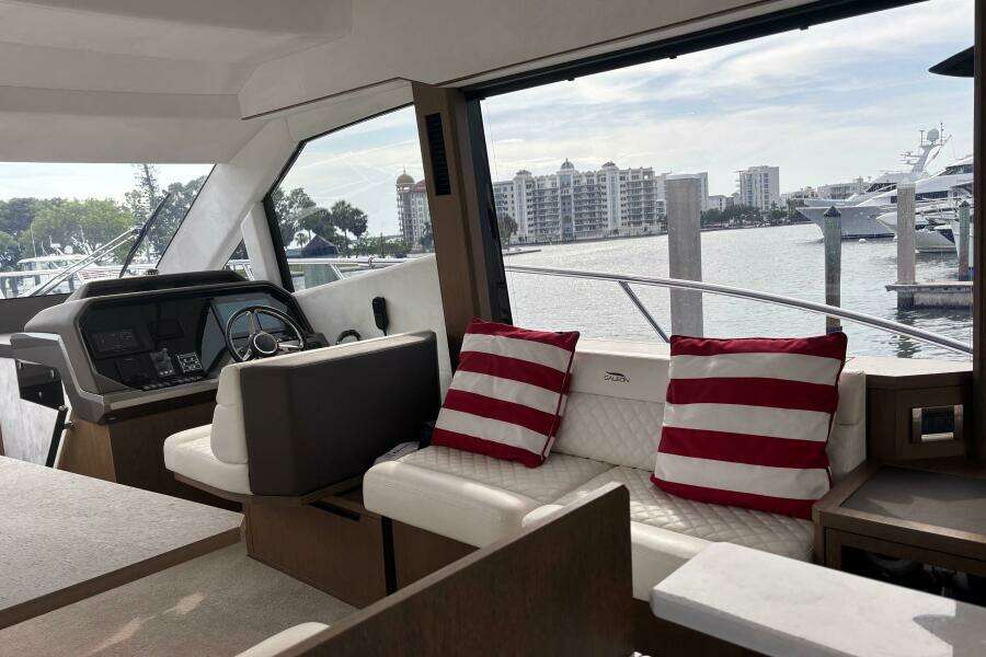 Interior of 2020 Galeon 500 Fly yacht with striped cushions and waterfront view.