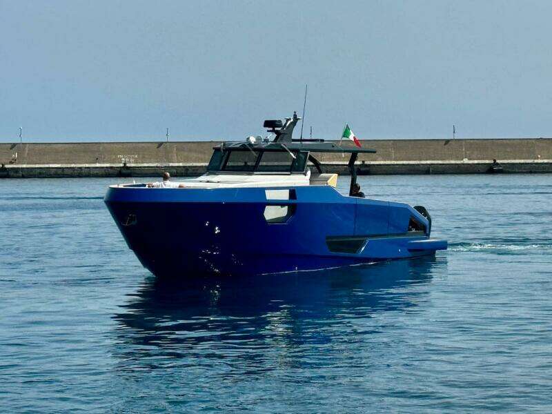 Aicon Audace 50 yacht, 2025 model, cruising in calm waters near a concrete pier.