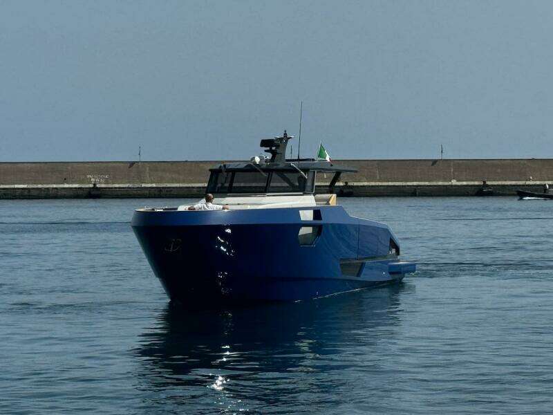 2025 Aicon Audace 50 yacht in a harbor, featuring sleek blue design.