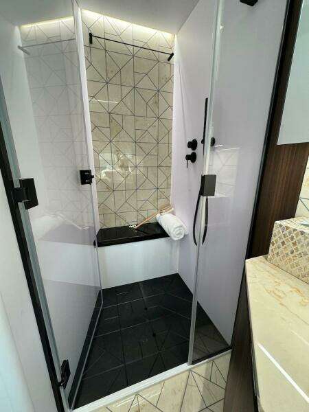 Luxurious shower in 2024 Aicon 66 Vivere yacht with modern geometric tiles.