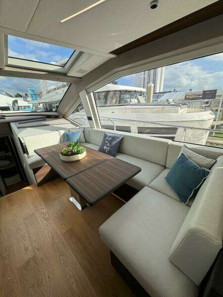 Luxurious interior of 2024 Aicon 66 Vivere yacht with elegant seating and table.
