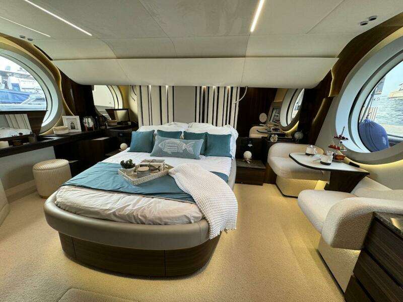 Luxurious bedroom interior of 2024 Aicon 66 Vivere yacht with elegant decor and round windows.