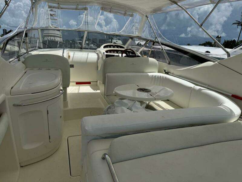 2003 Cranchi Endurance 39 yacht interior with white seating and helm, under a clear canopy.