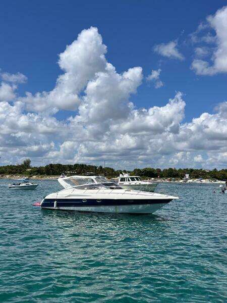 2003 Cranchi Endurance 39 yacht on clear blue water under a cloudy sky.