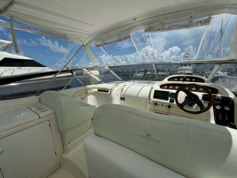 2003 Cranchi Endurance 39 yacht interior with helm, white seating, and clear canopy.