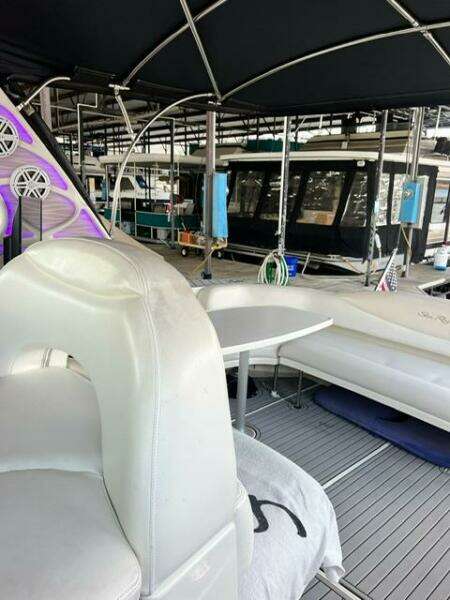 2003 Sea Ray 380 Sundancer interior with seating and table under canopy.