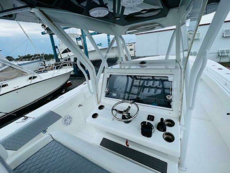 2020 SeaHunter 39 Tournament boat cockpit with steering wheel and controls, docked near other boats.