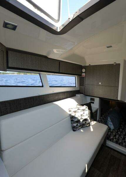 Interior of 2023 Monterey 385 Super Sport yacht with modern seating and windows.