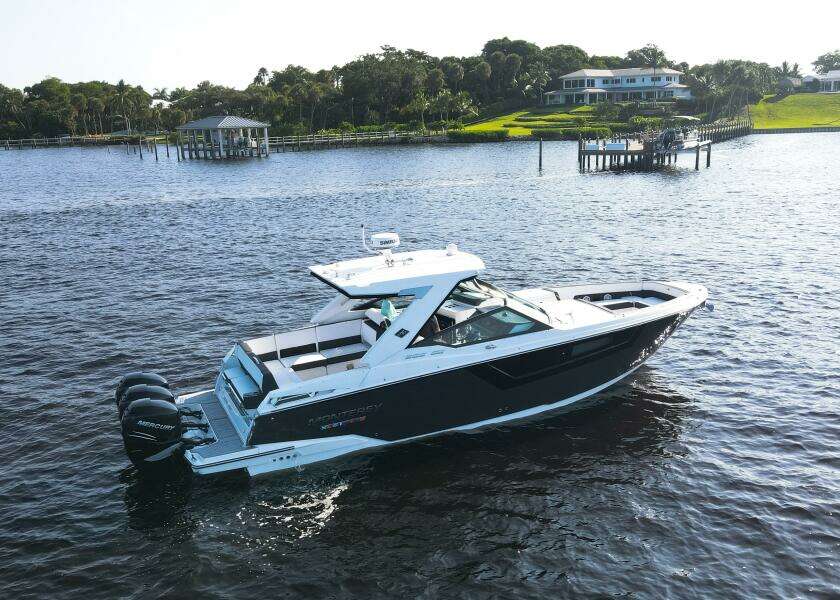 2023 Monterey 385 Super Sport boat cruising on a serene lake with scenic background.